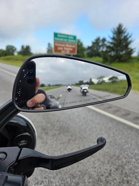 motorcycles in a motorcycle mirror on a trip riding down the highway
