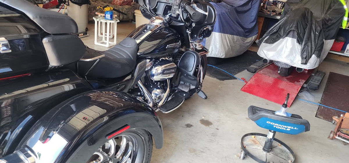 Black motorcycle in a garage with tools and equipment around