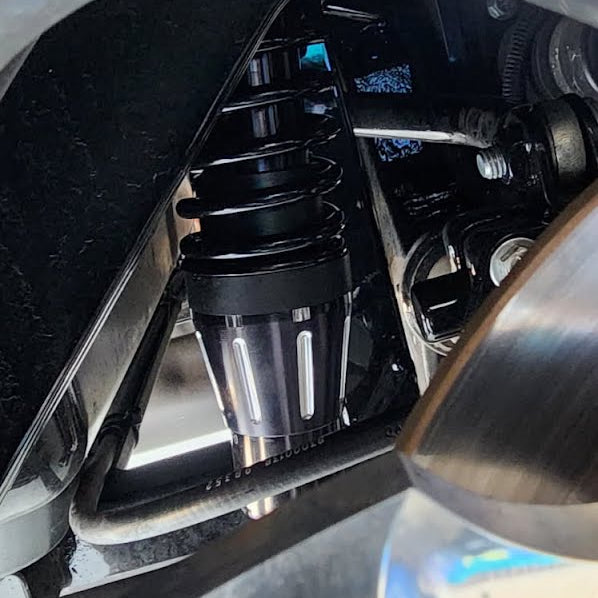 Close-up of a motorcycle's suspension system with metal components.