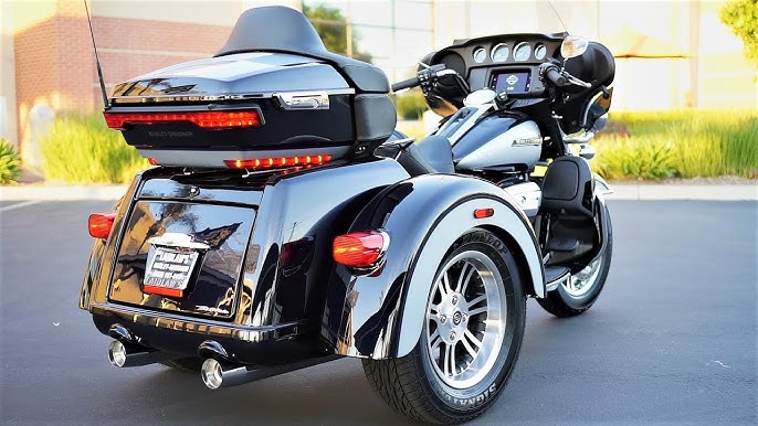 Black trike motorcycle on a road with a blurred background